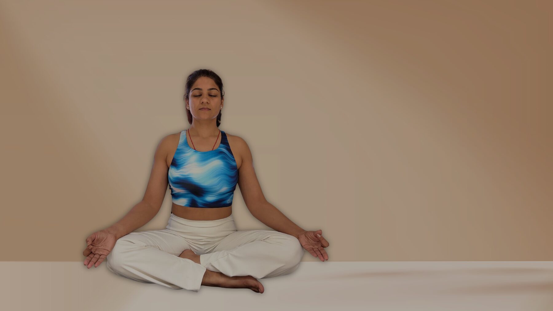 Divya seated cross-legged in meditation